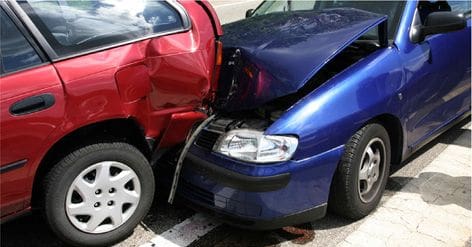 A blue car is in the back of another red car